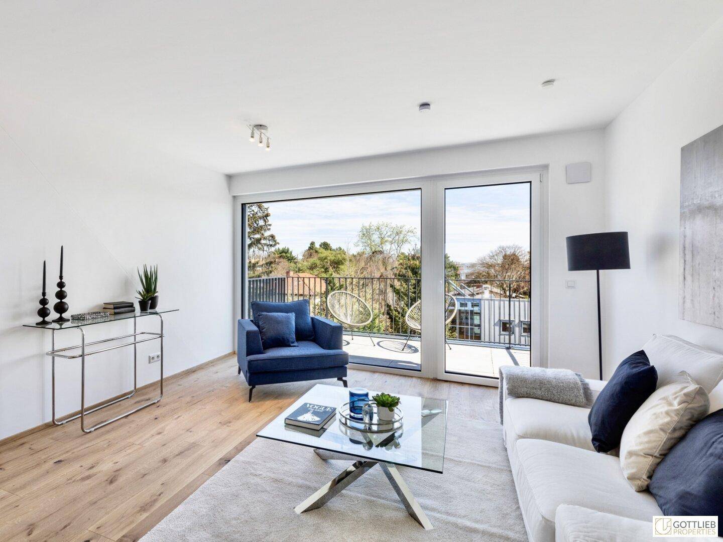 Heller Wohnbereich mit bequemen Sofas, Glastisch und Zugang zum Balkon.