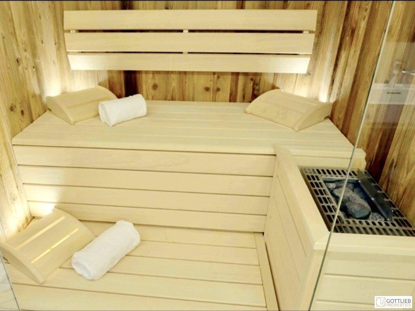 Moderne Holzsauna mit Bänken und Heizofen, ideal zur Entspannung.