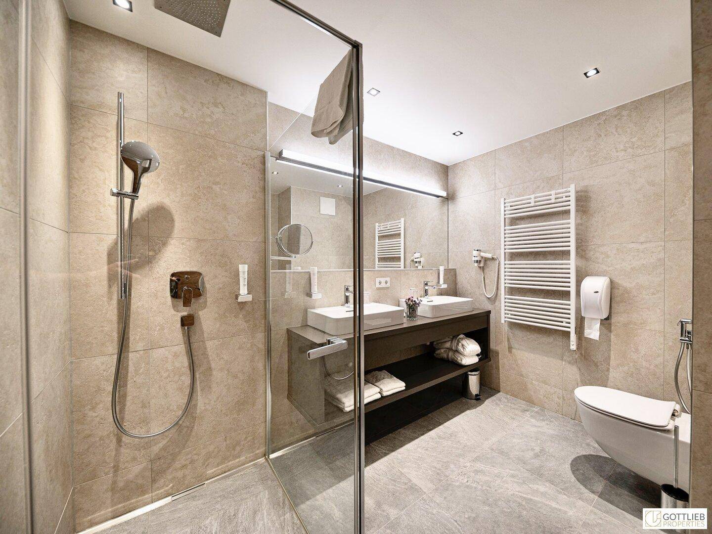 Geräumiges Badezimmer mit Doppelwaschbecken, begehbarer Dusche und beheiztem Handtuchhalter.