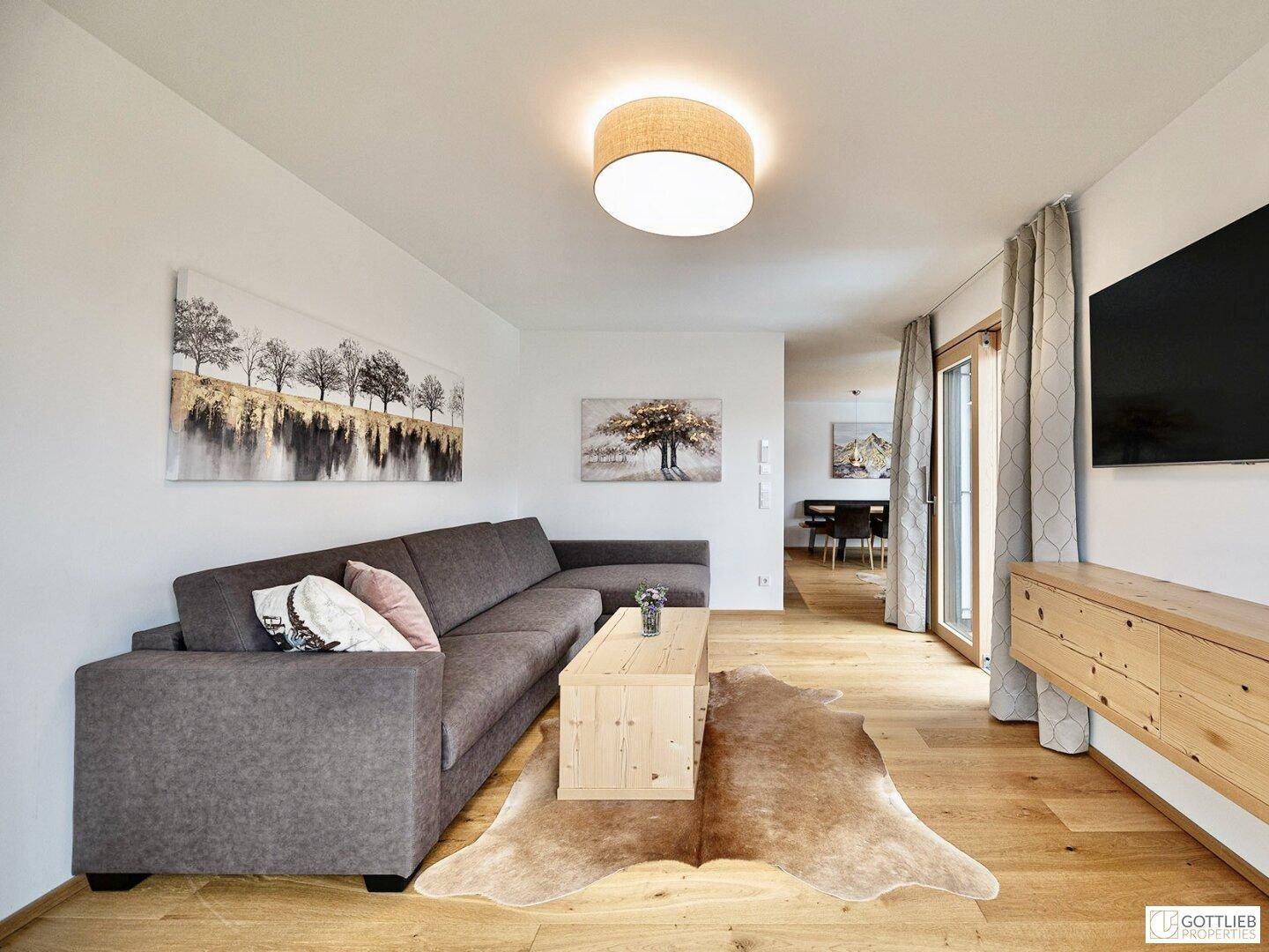 Geräumiges Wohnzimmer mit großem Ecksofa, Holztisch und dekorativem Teppich, hell und modern.