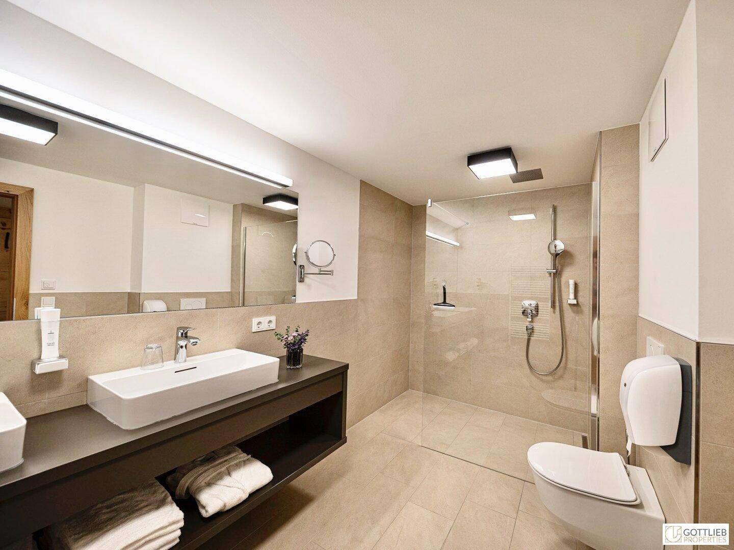 Elegantes Badezimmer mit großem Spiegel, modernem Waschbecken und geräumiger Duschkabine.