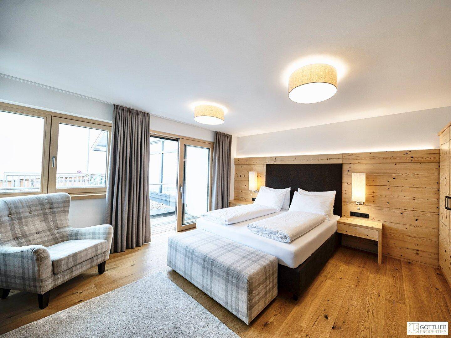 Helles Schlafzimmer mit bequemen Möbeln und großen Fenstern, die den Raum mit Licht füllen.