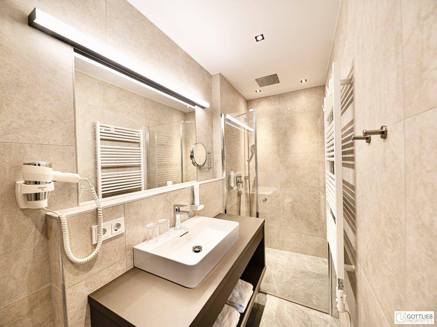 Modernes Badezimmer mit begehbarer Dusche, Einzelwaschbecken und Handtuchheizkörper.