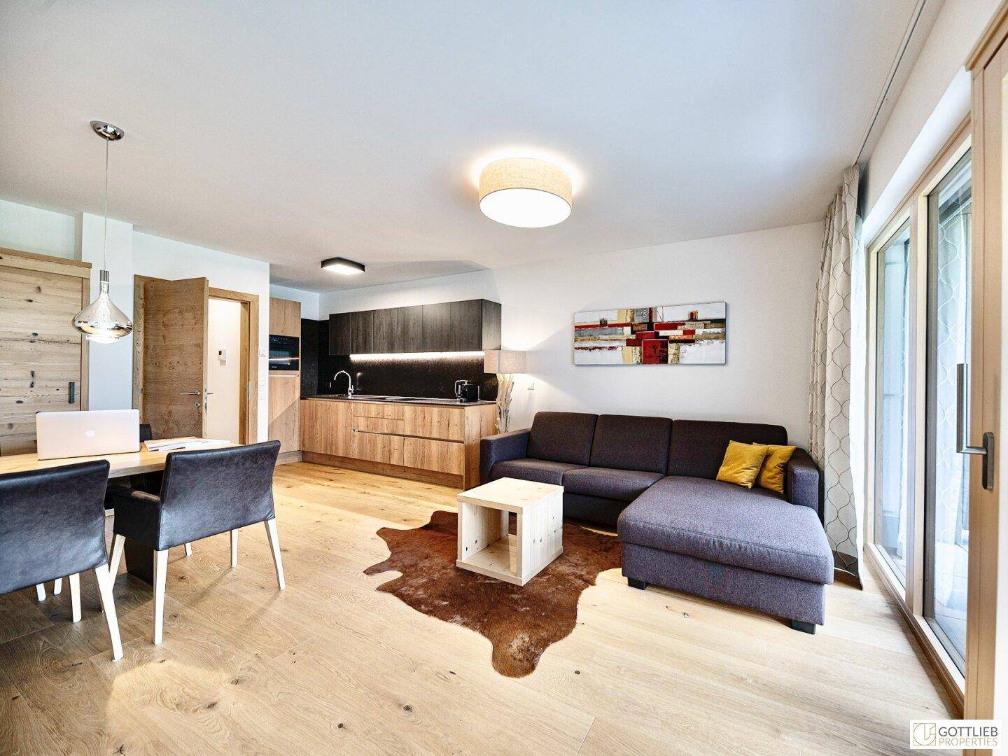 Offener Wohnbereich mit integrierter Küche, Essbereich und gemütlichem Sofa, hell und modern.