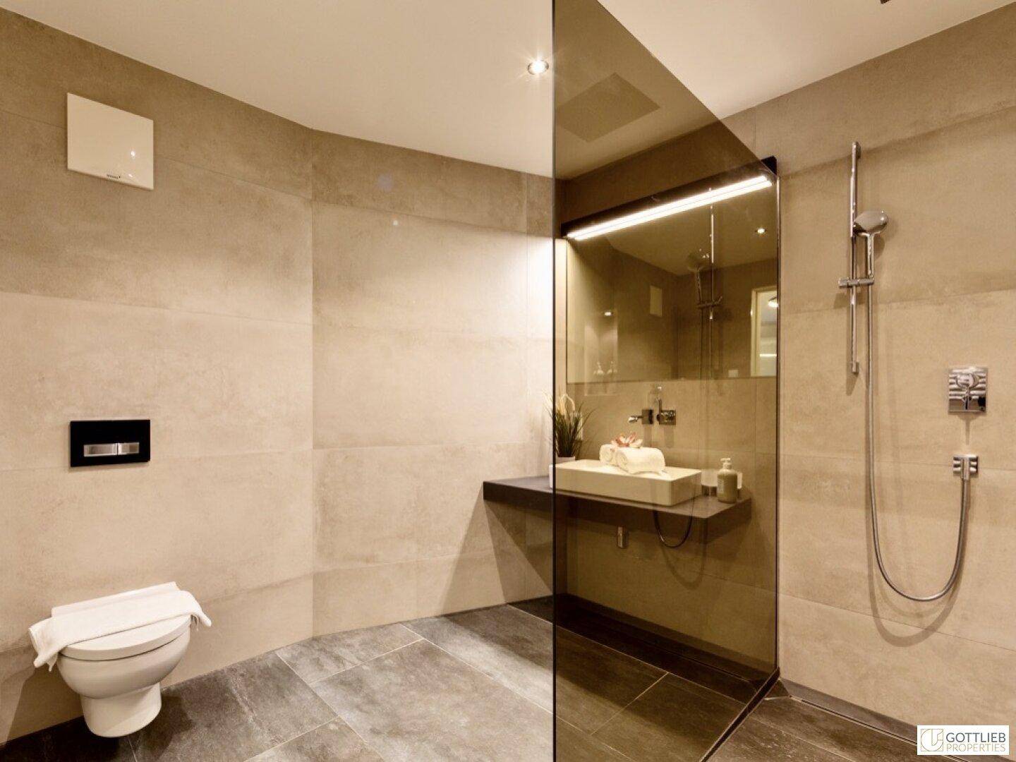 Elegantes Badezimmer mit wandmontierter Toilette, begehbarer Dusche und modernen Armaturen.