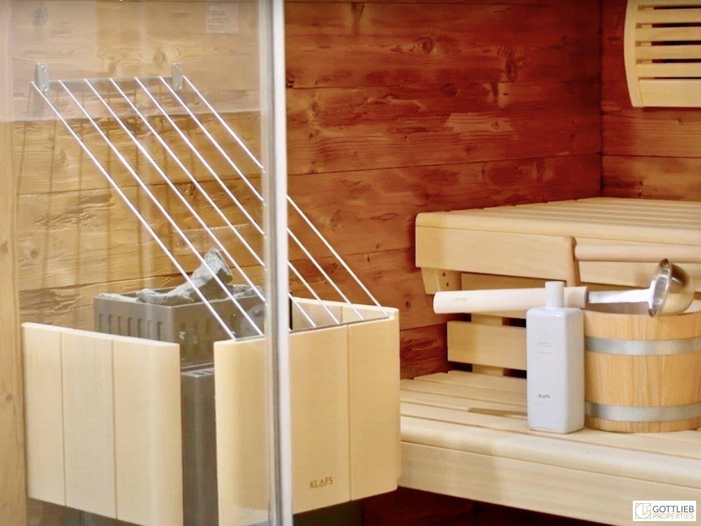 Gemütliche Holzsauna mit traditionellem Ofen, Holzbänken und Zubehör für Entspannung.