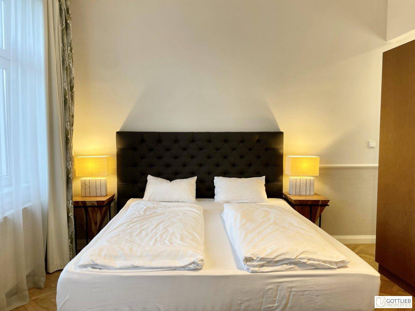 Schlafzimmer mit bequemem Doppelbett, Nachttischen und indirekter Beleuchtung, ideal zum Entspannen.