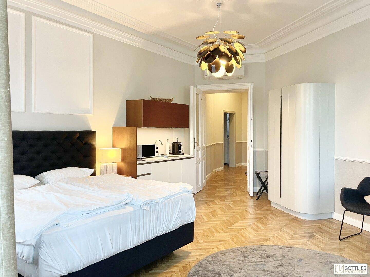 Helles Studio-Apartment mit Schlafbereich, integrierter Küchenzeile und Essbereich, modern eingerichtet.