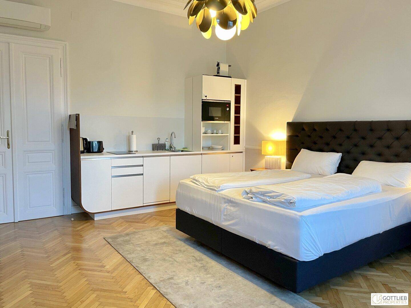 Helles Studio-Apartment mit Doppelbett und integrierter Küchenzeile, ideal für Einzelpersonen oder Paare.