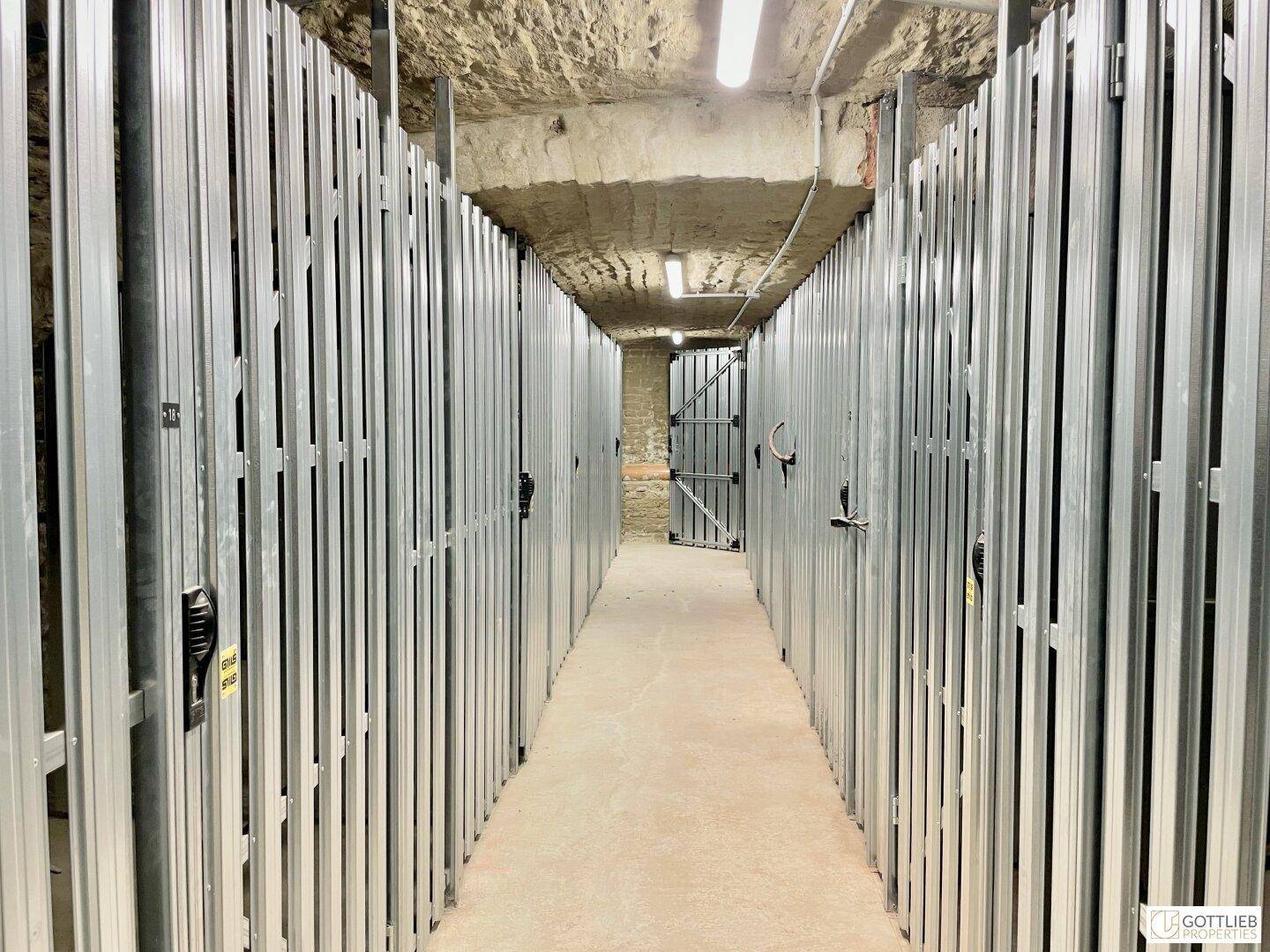 Kellerabteile mit Metallabtrennungen und Betonboden, bieten sicheren Stauraum für Bewohner.