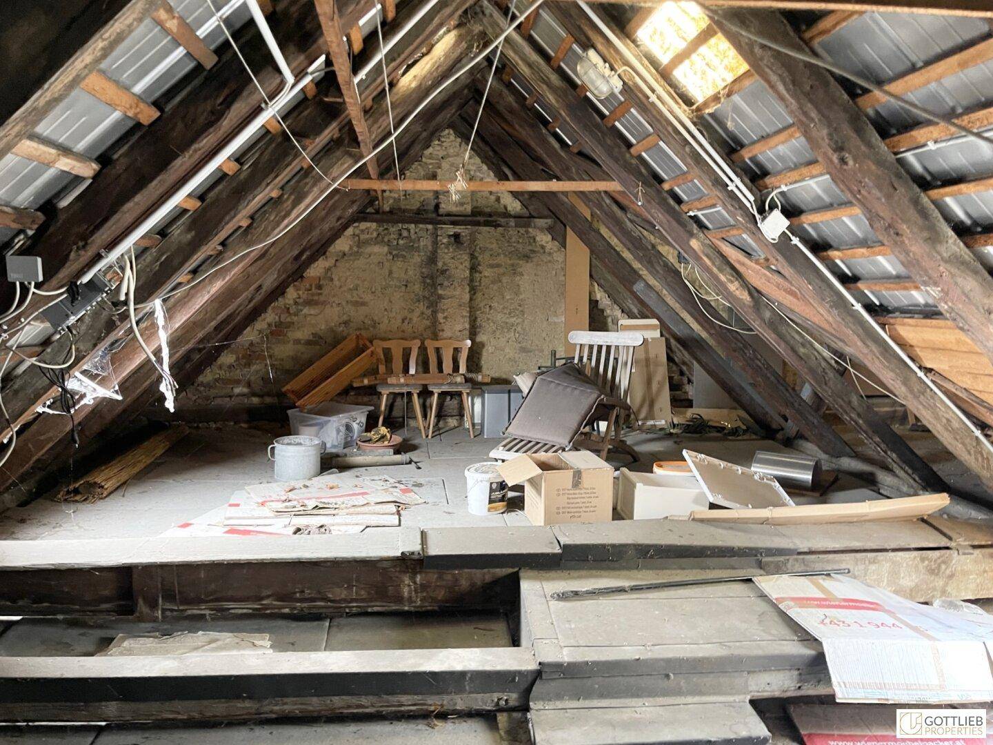 Geräumiger Dachboden mit freiliegenden Holzbalken und viel Stauraum, bereit für den Ausbau.