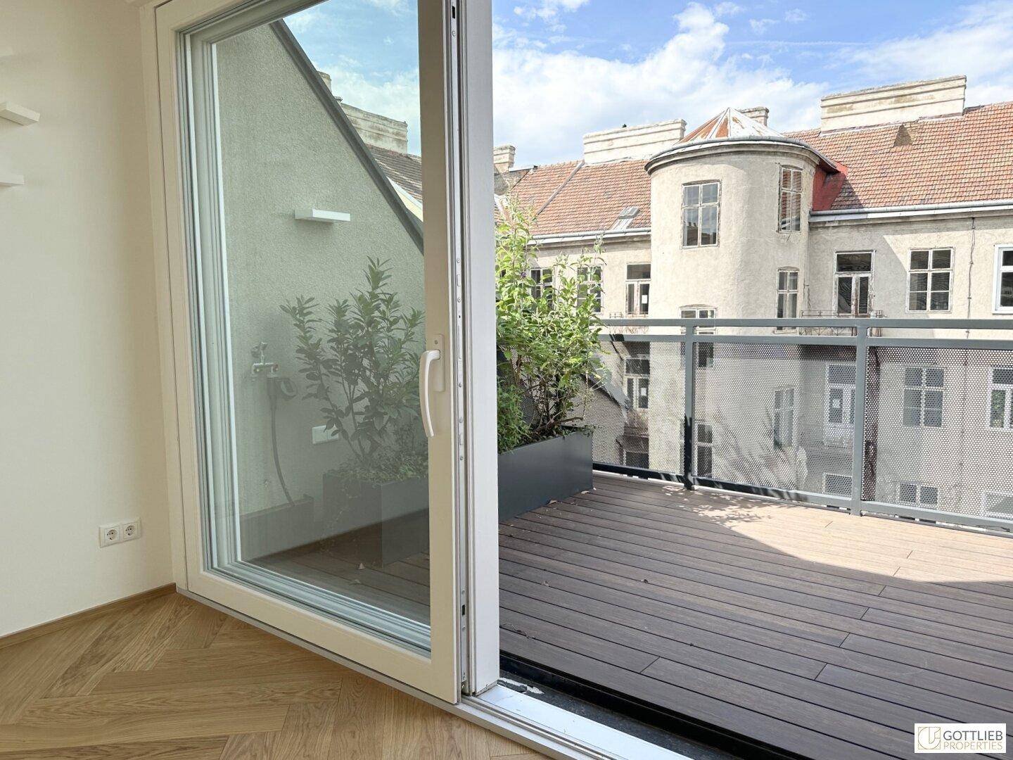 Innenansicht mit großem Schiebefenster und direktem Zugang zur sonnigen Terrasse.