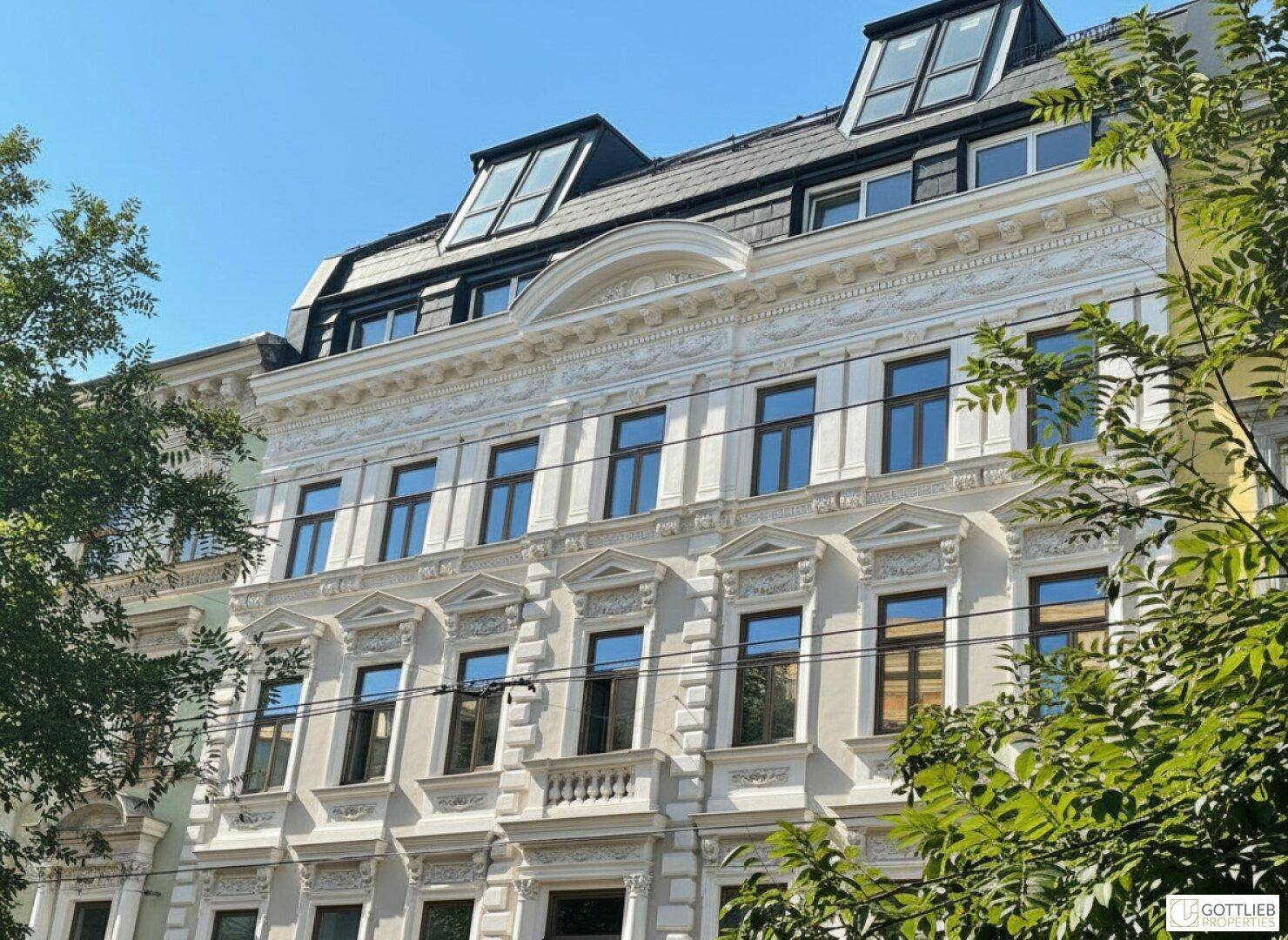 Historische Fassade eines Gebäudes mit reich verzierten Details und Dachgauben.