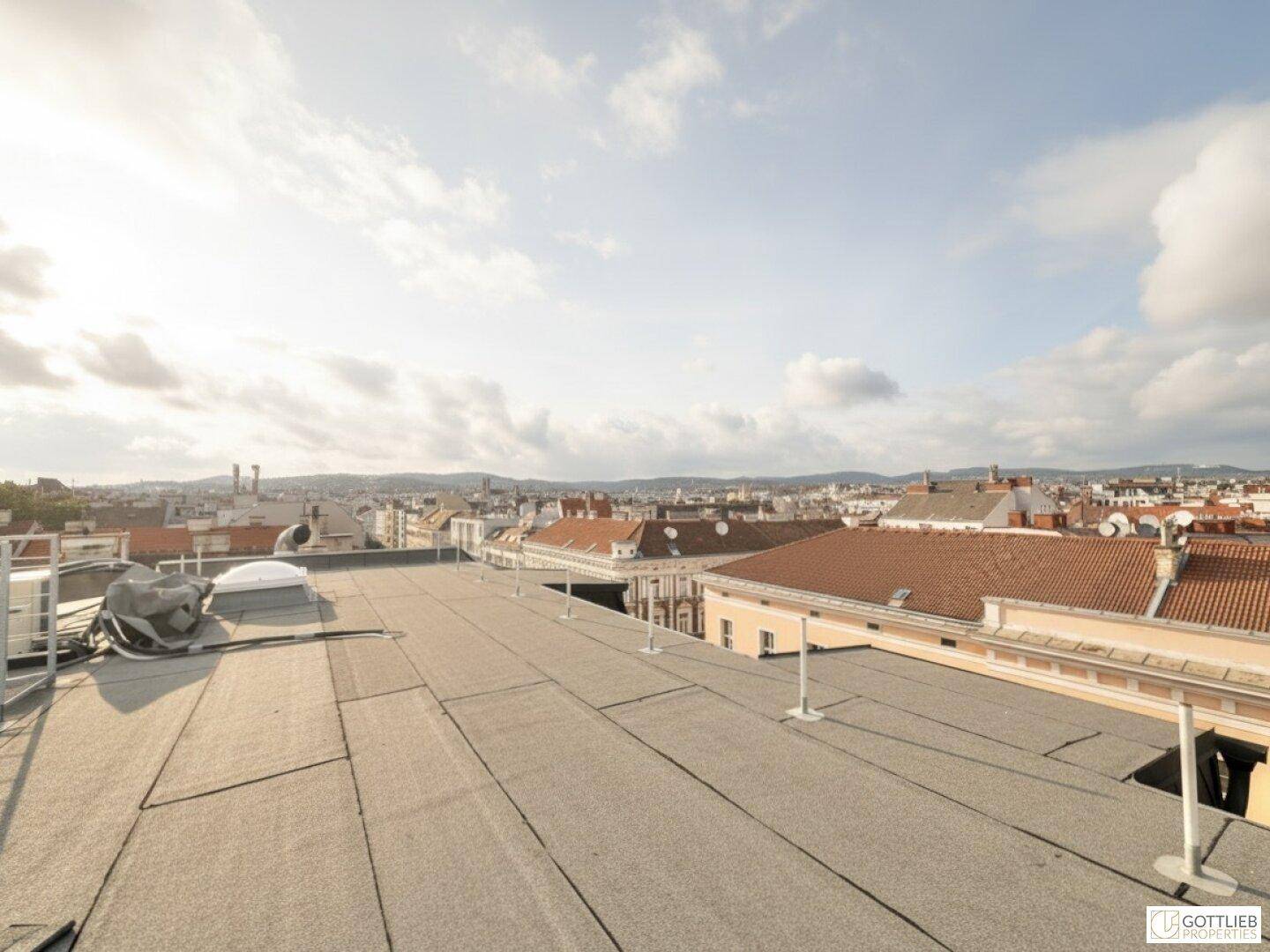 Flachdachbereich mit Blick über die Dächer der Stadt und die umliegende Landschaft.