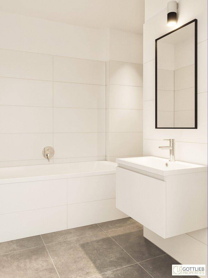 Modernes Badezimmer mit weißen Fliesen, integrierter Badewanne und elegantem Waschtisch.