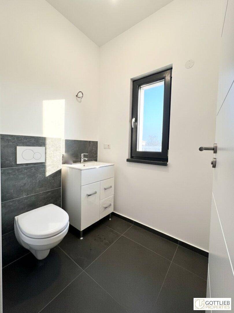 Kleines Badezimmer oder Gäste-WC mit Fenster, wandhängendem WC und modernem Waschtisch.