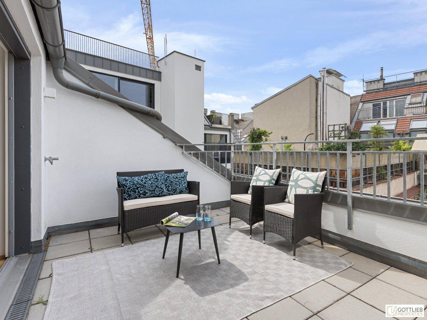 Weitläufige Terrasse mit Blick auf die Stadt und die umliegenden Dächer, ideal zum Entspannen.