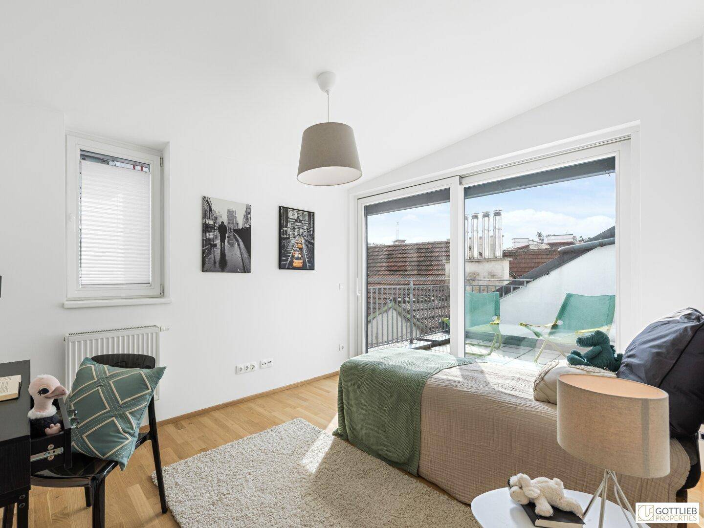 Helles Schlafzimmer mit Einzelbett, Schreibtisch und direktem Zugang zu einem sonnigen Balkon.