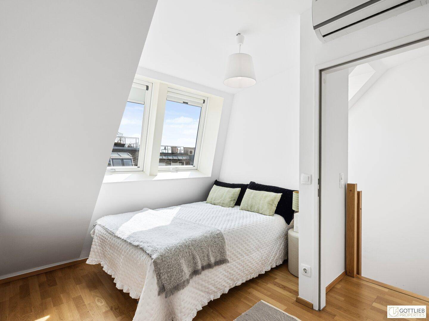 Gemütliches Schlafzimmer mit Doppelbett, Dachschräge und hellen Dachfenstern, die viel Licht spenden.