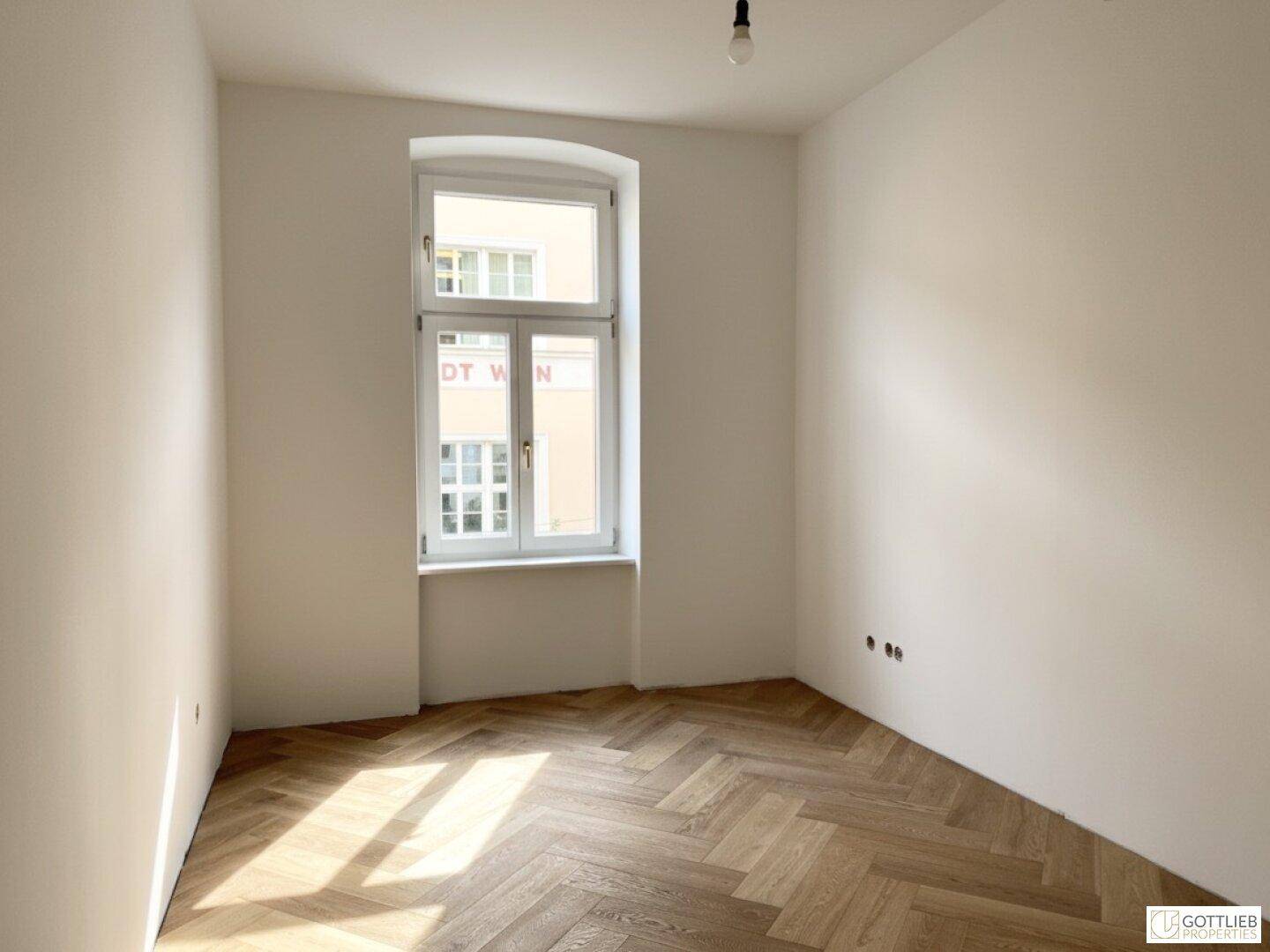 Kleinerer, heller Raum mit Fischgrätparkett und einem hohen Fenster, vielseitig nutzbar.