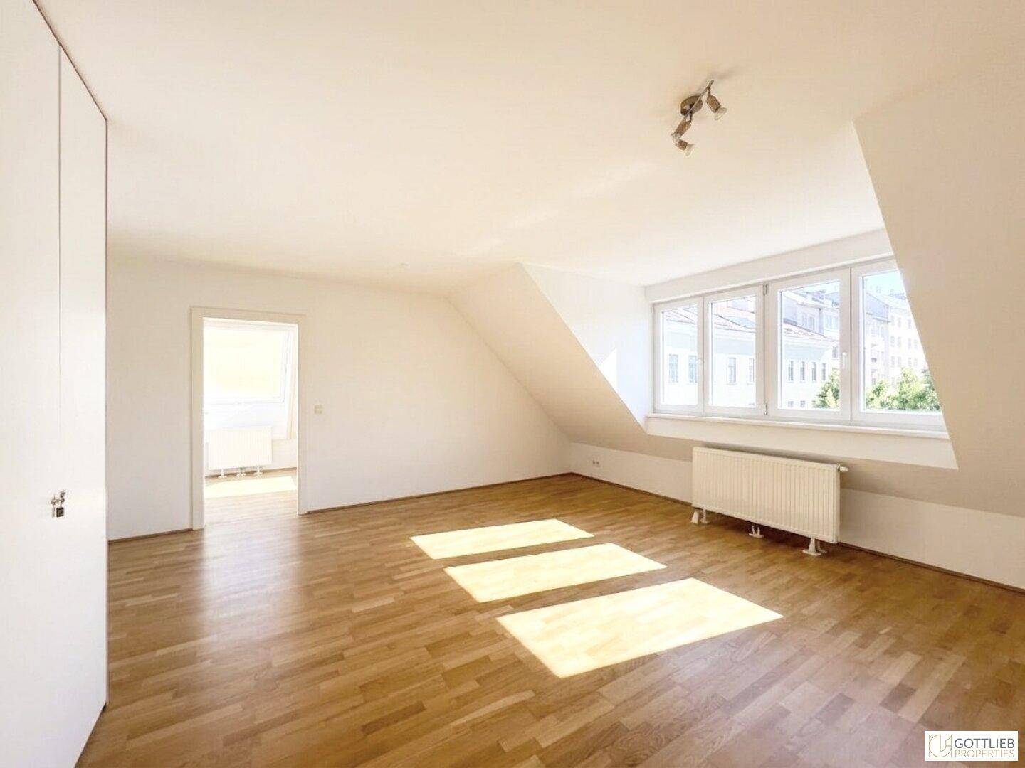 Geräumiges, helles Zimmer im Dachgeschoss mit Holzboden und Einbauschränken.