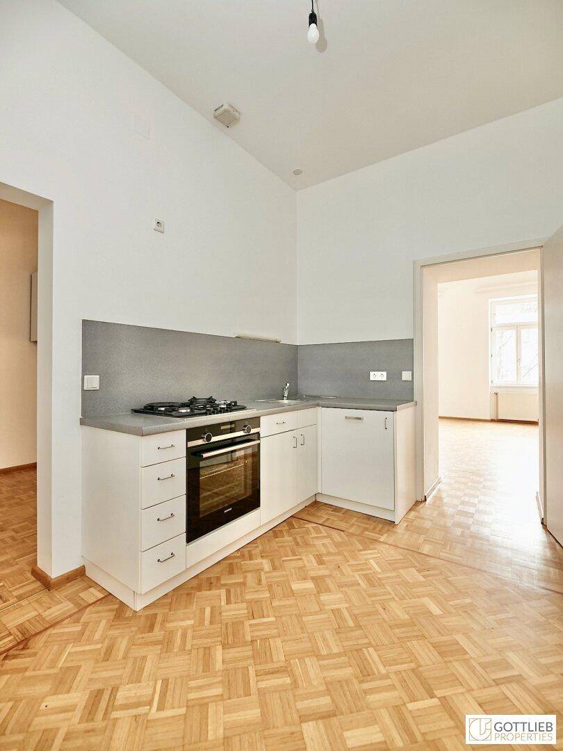 Funktionale kleine Küche mit Gasherd, Backofen und weißen Unterschränken, ausgestattet für den täglichen Gebrauch.