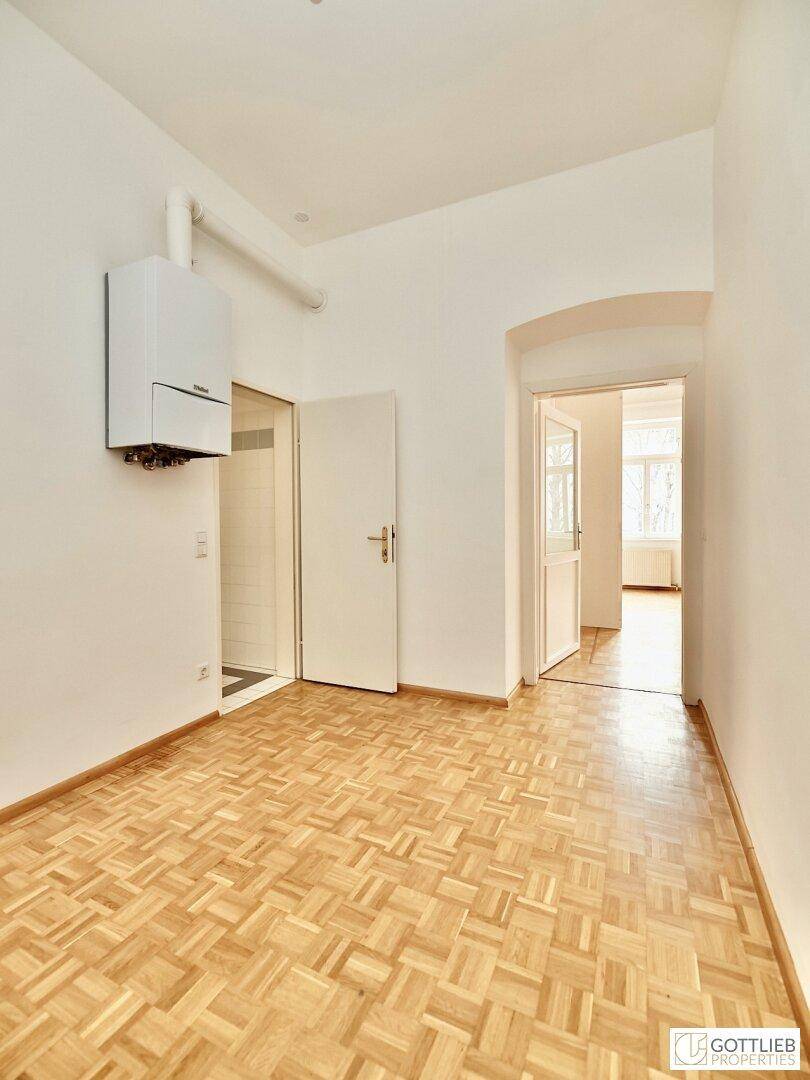 Geräumiges Zimmer mit Parkettboden, Heizkessel und Zugang zu einem Badezimmer, vielseitig nutzbar.