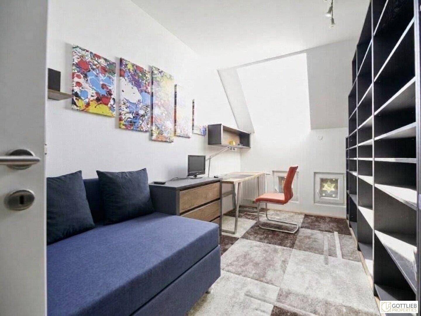Gemütliches Zimmer mit Tagesbett, Schreibtisch und großem Bücherregal unter der Dachschräge.