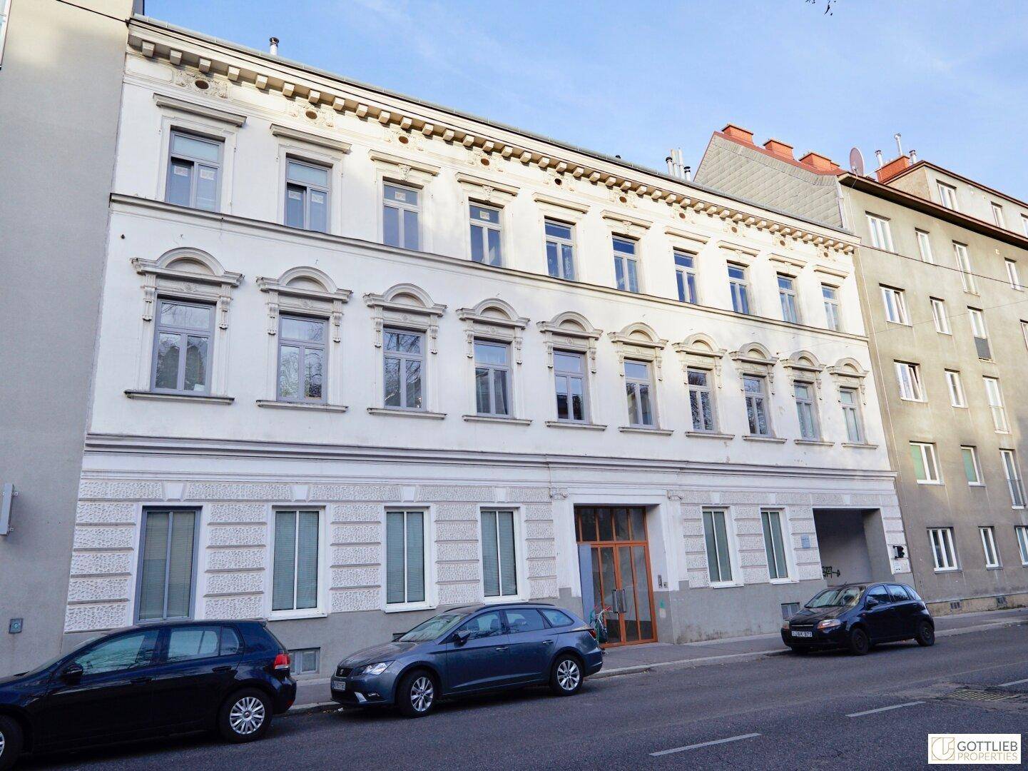 Historische Fassade eines Mehrfamilienhauses an einer städtischen Straße.
