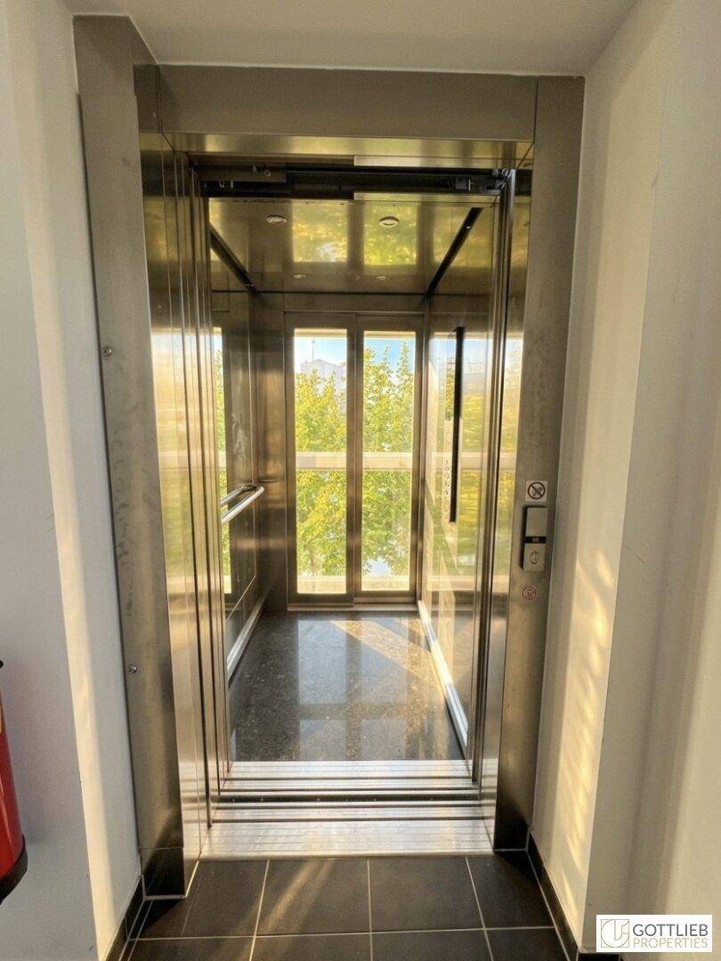 Moderner Aufzug mit Glaswänden bietet einen hellen Blick nach draußen.