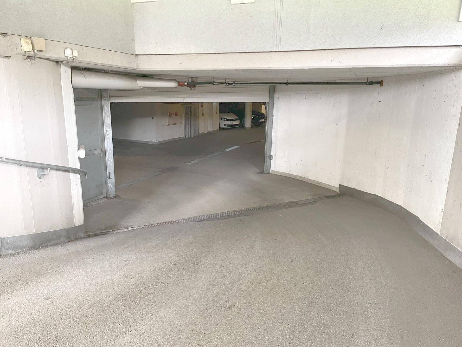 Blick von der Zufahrt in die Tiefgarage, mit weiteren Parkplätzen im Inneren.