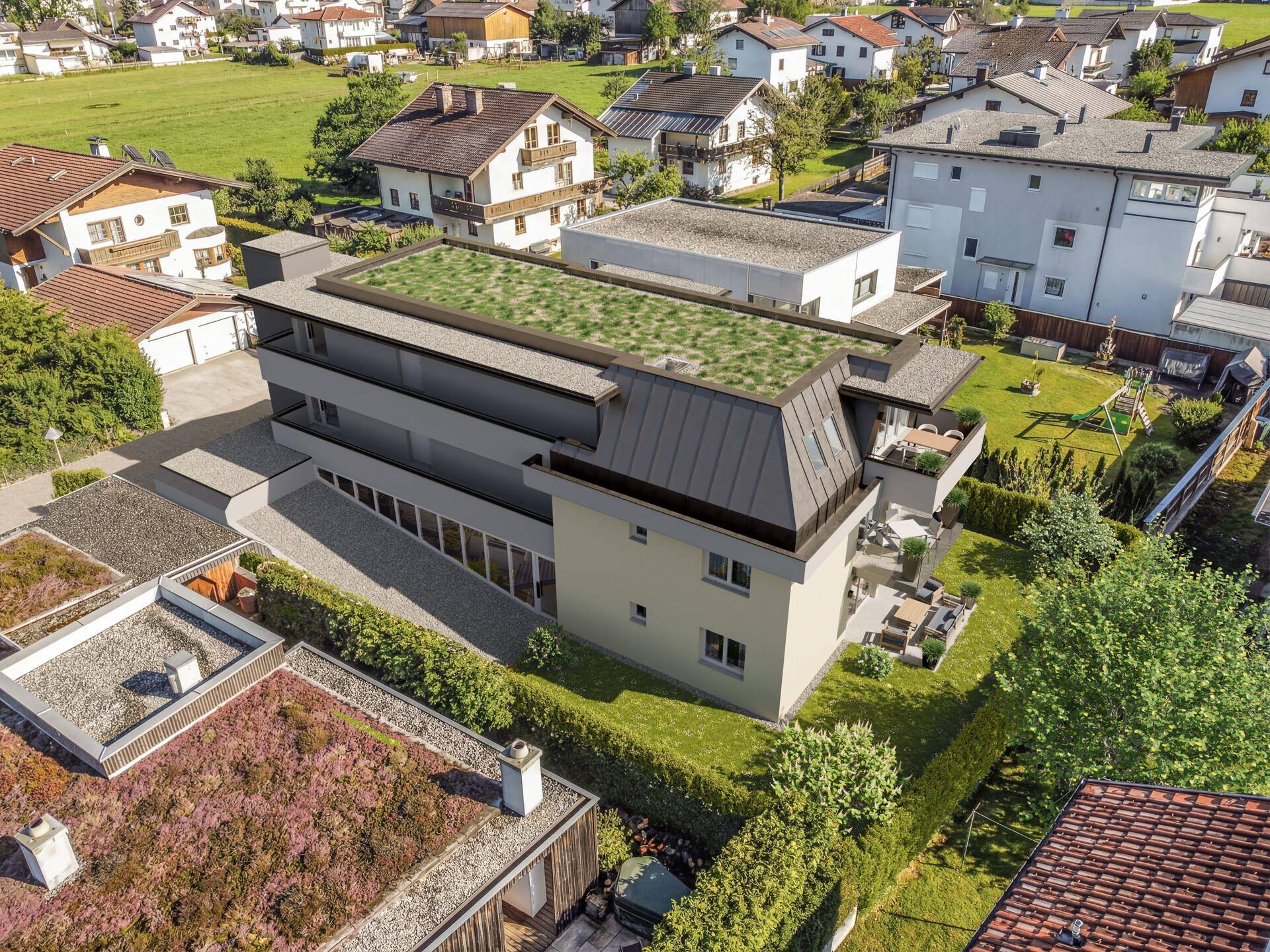 Ansicht der modernen Wohnanlage von hinten mit begrüntem Dach und Terrassen in ländlicher Umgebung.