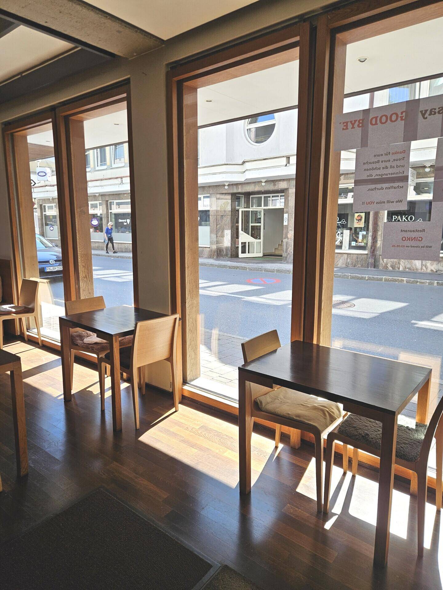Große Fensterfront im Restaurant, die viel Tageslicht hereinlässt und einen Blick auf die Straße bietet.