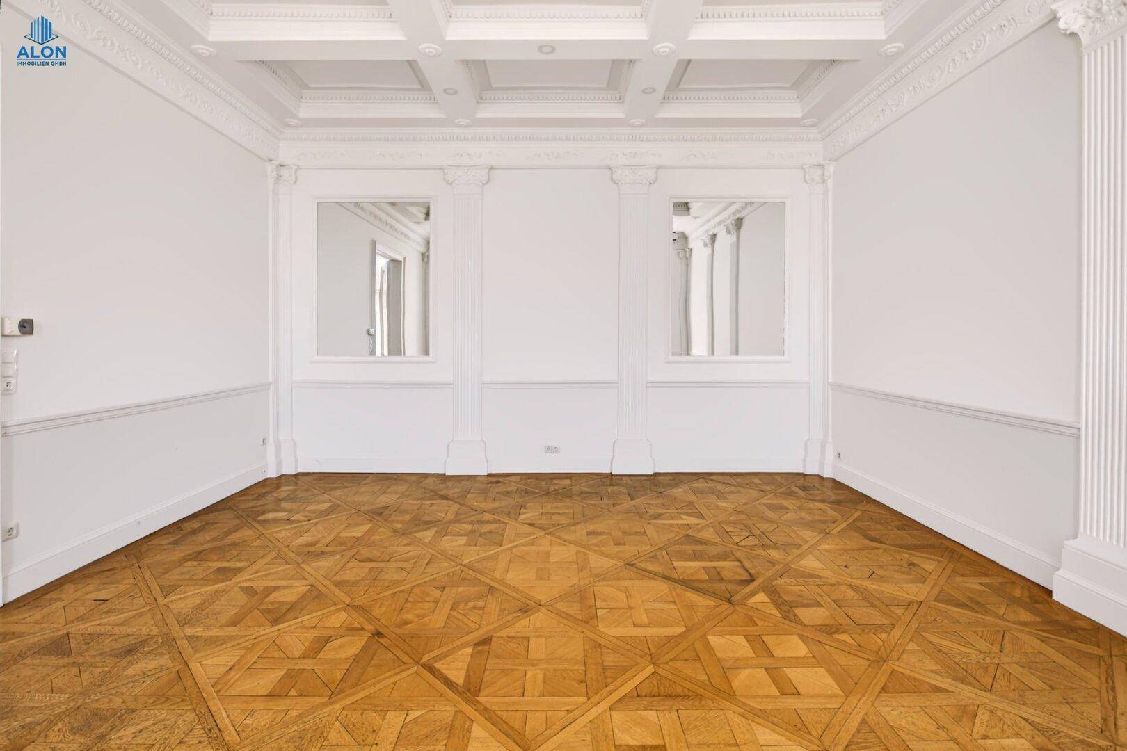 Elegantes Zimmer mit Kassettendecke, Parkettboden und dekorativen Säulen, die den Raum schmücken.