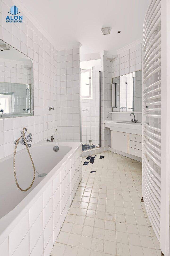 Geräumiges Badezimmer mit Badewanne, Dusche, Doppelwaschbecken und weißen Fliesen, in gutem Zustand.