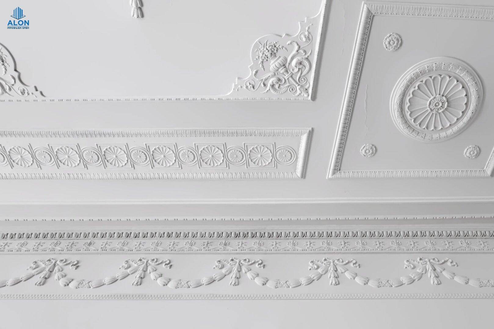 Detailaufnahme einer aufwendig verzierten Stuckdecke mit klassischen Ornamenten, die Eleganz ausstrahlt.