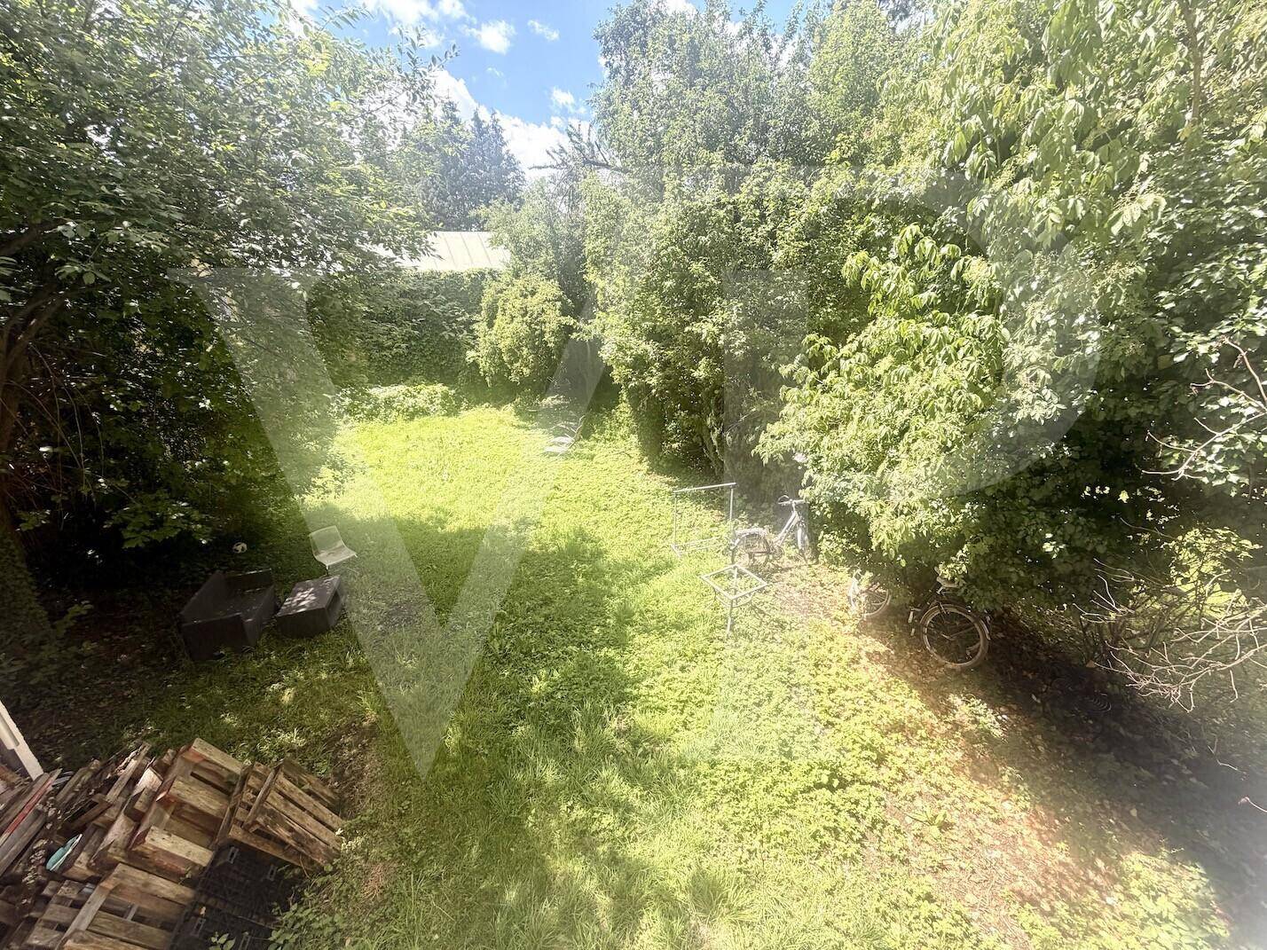 Naturbelassener Gartenbereich mit viel Grün und Bäumen, bietet Ruhe und Privatsphäre.
