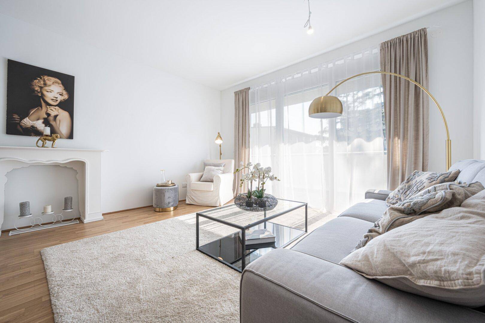 Helles Wohnzimmer mit Parkettboden, beigem Teppich und dekorativem Kamin.