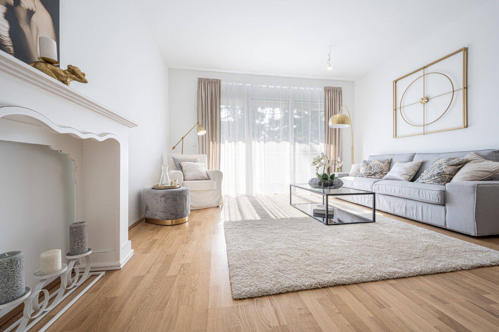 Lichtdurchflutetes Wohnzimmer mit Holzboden, beigem Teppich und stilvoller Einrichtung.