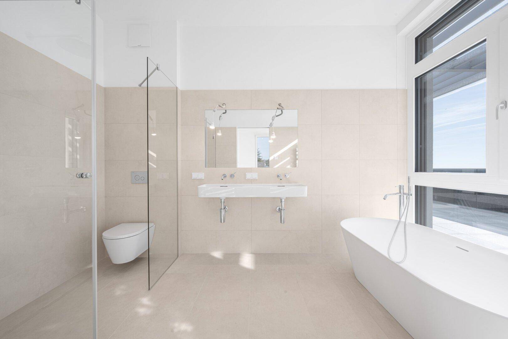 Modernes Badezimmer mit Doppelwaschbecken, freistehender Badewanne und großer Dusche.