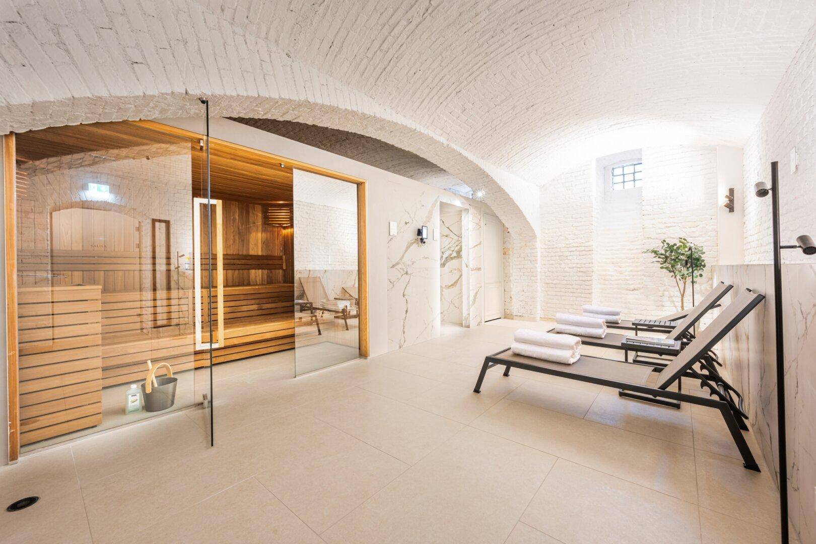 Moderner Wellnessbereich im Gewölbekeller mit Sauna, Liegen und entspannender Atmosphäre.
