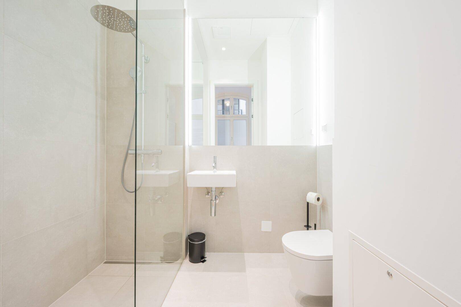 Modernes Badezimmer mit begehbarer Dusche, wandhängendem WC und minimalistischem Design.