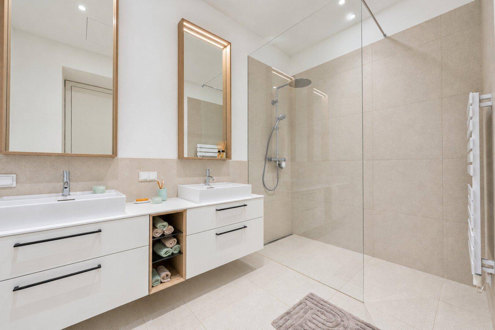 Modernes Badezimmer mit Doppelwaschbecken, großer Dusche und beheiztem Handtuchhalter.