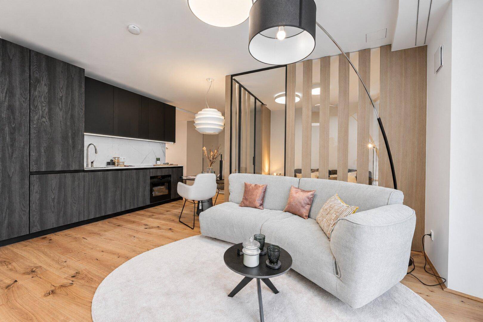 Gemütlicher Wohnbereich mit integrierter Küchenzeile, Holzboden und moderner Einrichtung.