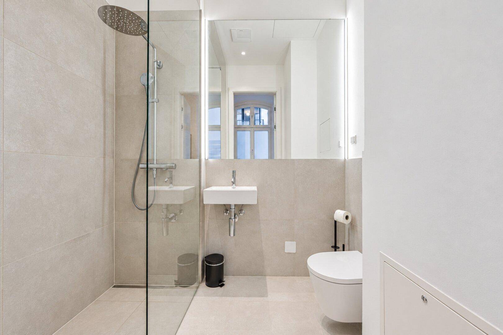 Modernes Badezimmer mit ebenerdiger Dusche, Wand-WC und kleinem Waschbecken.
