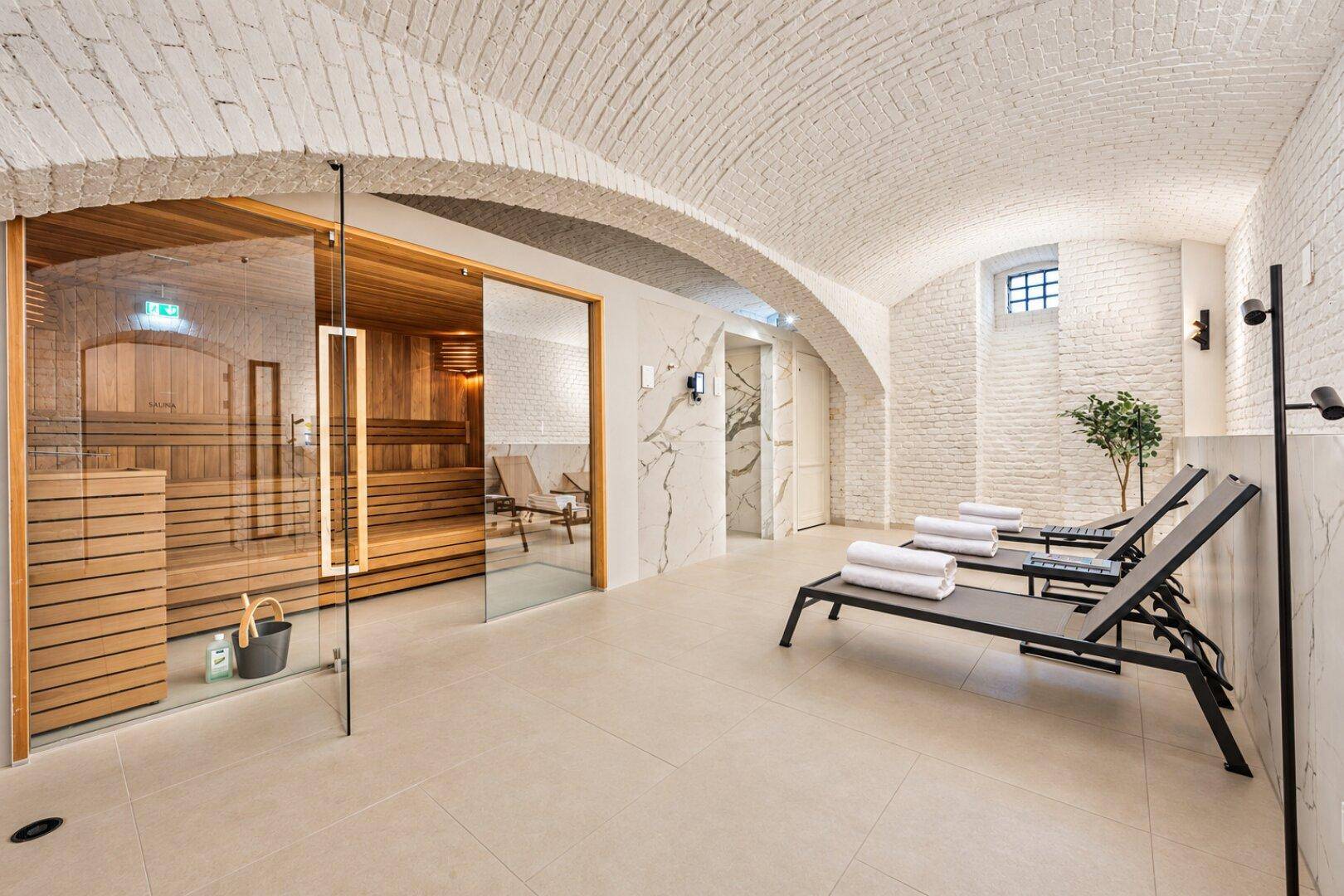 Entspannender Wellnessbereich mit Sauna, Liegen und charakteristischen Gewölbedecken aus Ziegeln.