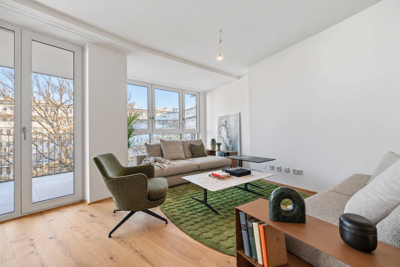 Helles Wohnzimmer mit Holzboden, modernem Mobiliar und Zugang zu einem Balkon.