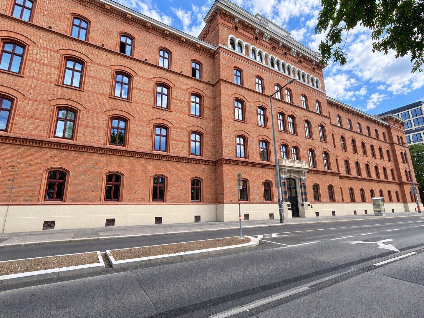 Beeindruckende Backsteinfassade eines historischen Gebäudes mit vielen Fenstern und klassischer Architektur.