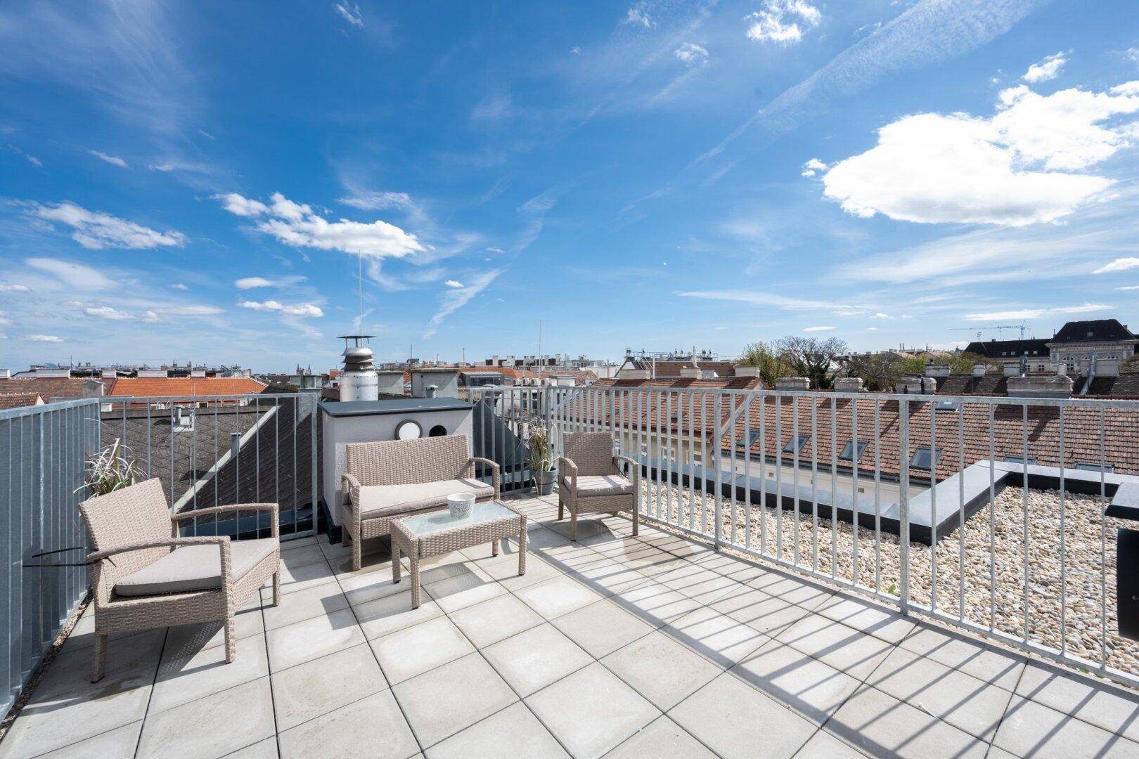 Geräumige Dachterrasse mit Loungemöbeln und weitem Blick über die Stadt.