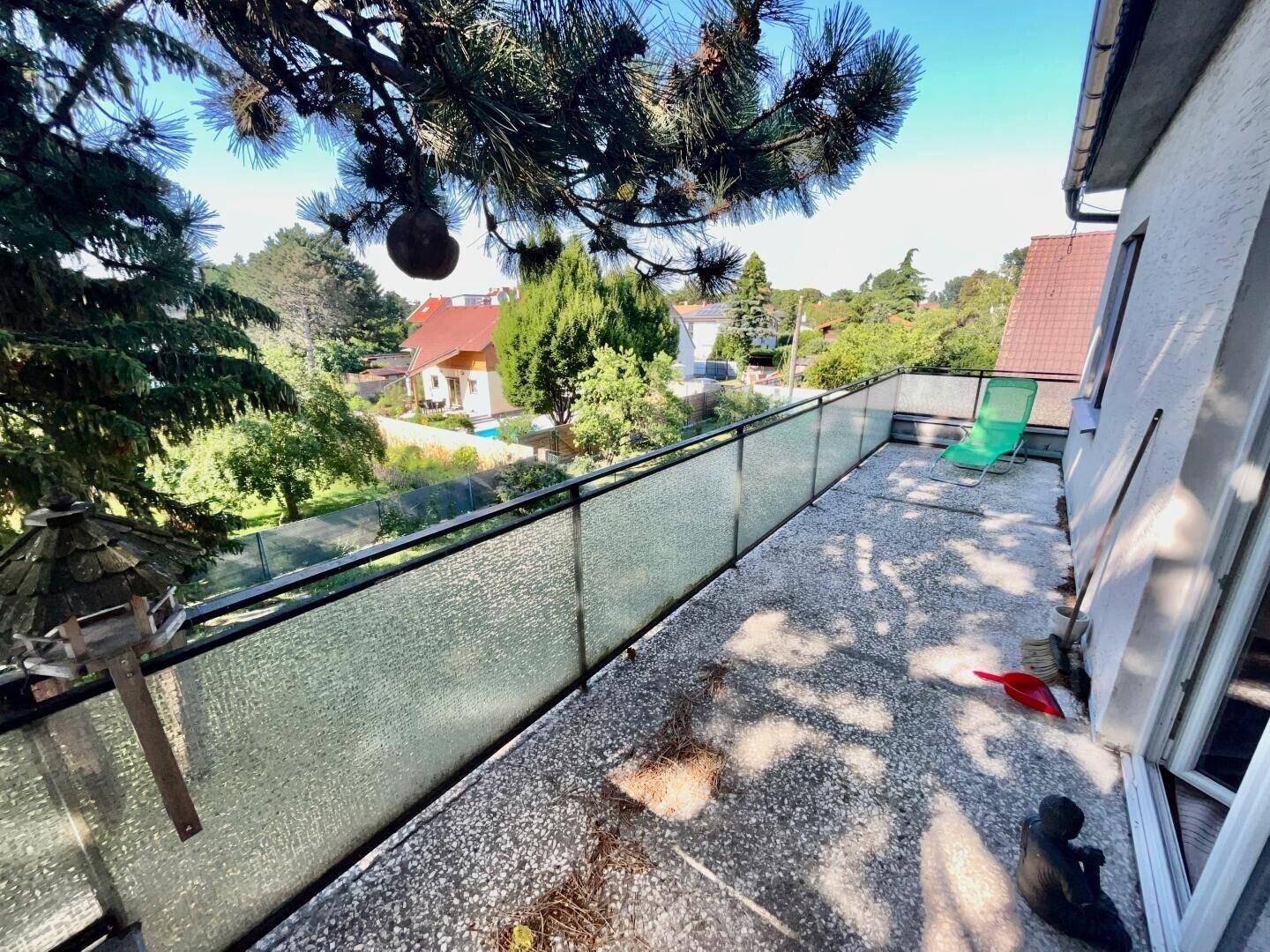 Geräumiger Balkon mit Glasgeländer und Blick ins Grüne, ideal zum Entspannen.